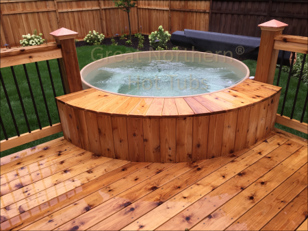 <p>Round cedar hot tub built into the corner of new wooden backyard back.</p>