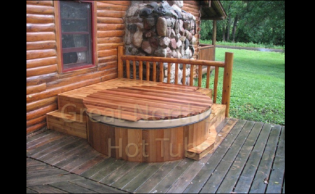 <p>Rubadub Tub® western red cedar hot tub built into a deck outside a log cabin home.</p>