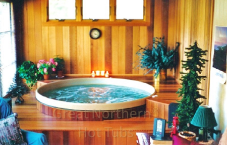 <p>Sunroom installation of a round cedar wood hot tub built into a surrounding deck with two steps and a recessed edge.</p>