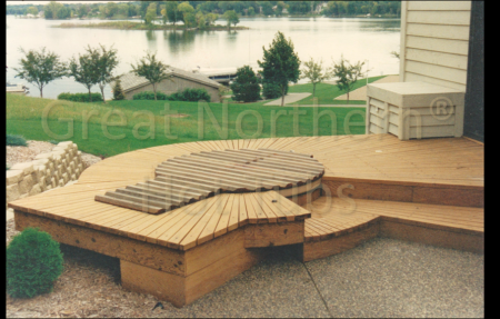 <p>Round hot tub recessed into a radial-planked deck with lake view.</p>