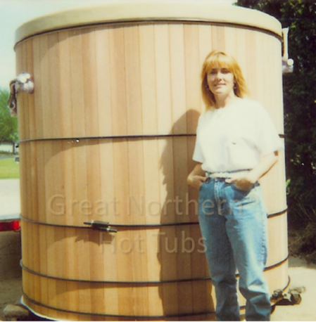 <p>Woman standing next to six-foot deep cedar wood hot tub. </p>