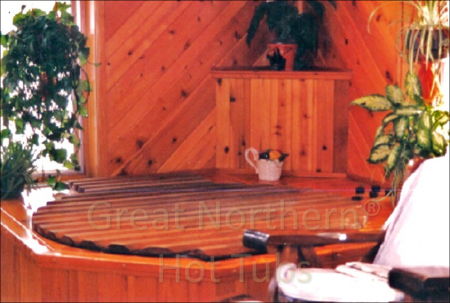<p>Round hot tub surrounded by a small deck for easy seating located in the corner of a family room.</p>