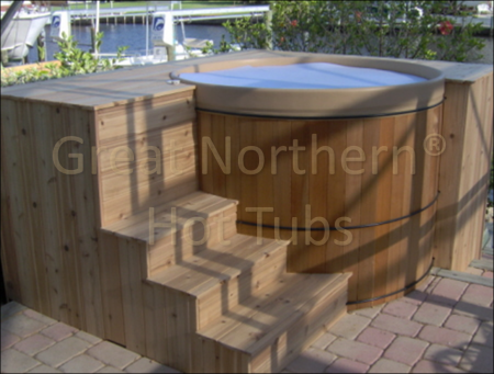<p>Free-standing portable round cedar hot tub in a deck with steps.</p>