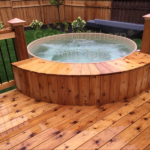 Redwood hot tub built into an outdoor deck, offering a seamless and luxurious outdoor experience