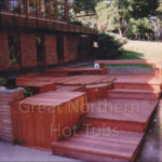 Redwood hot tub surrounded by a custom wooden deck for a seamless and luxurious outdoor experience