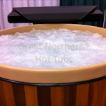 Redwood hot tub with bubbling water, offering a relaxing and therapeutic experience
