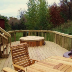 Outdoor redwood hot tub built into a wooden deck for a seamless and luxurious design