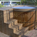 Cedar hot tub built into custom wooden decking for a seamless and stylish outdoor setup