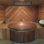 Cedar hot tub built into an indoor wood-fitted room for a seamless and cozy spa experience