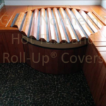 Indoor redwood hot tub built into a custom wood base with a rollup cover for a seamless and elegant design