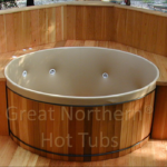 Outdoor redwood hot tub with a custom wood surround for a warm and elegant setting