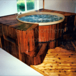 Indoor cedar hot tub with a custom wood surround for a luxurious spa-like experience