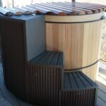 Large cedar hot tub with wooden steps for easy access and enhanced outdoor relaxation