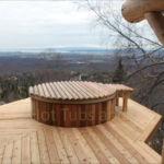 Cedar hot tub built into decking, offering a stunning outdoor view for a relaxing experience