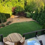 Small outdoor cedar hot tub with a sleek wooden finish surrounded by natural greenery