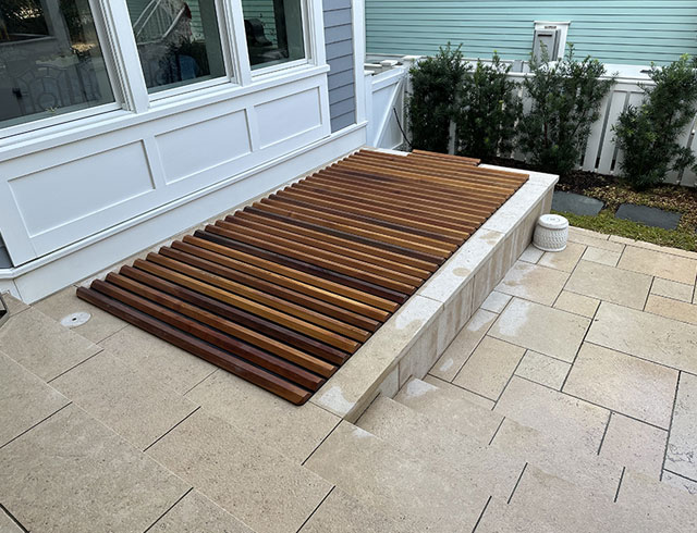 Modern roll-up cedar cover fits seamlessly into this clean and stylish backyard retreat.