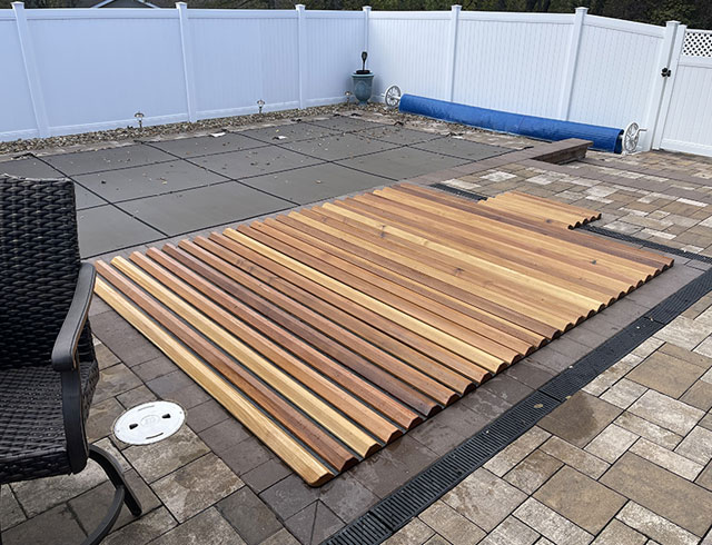Wide cedar roll-up cover offers reliable protection with a natural finish that complements any patio.